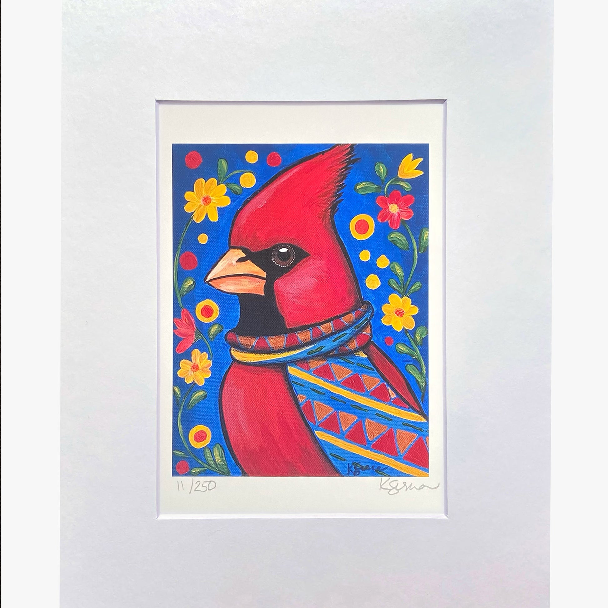 Framed artwork of a red cardinal bird with floral patterns on a blue background.