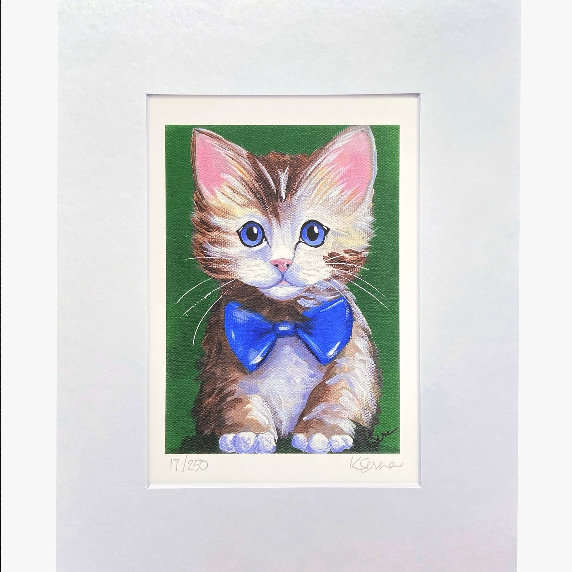 Framed artwork of a cat with a blue bow tie on a green background