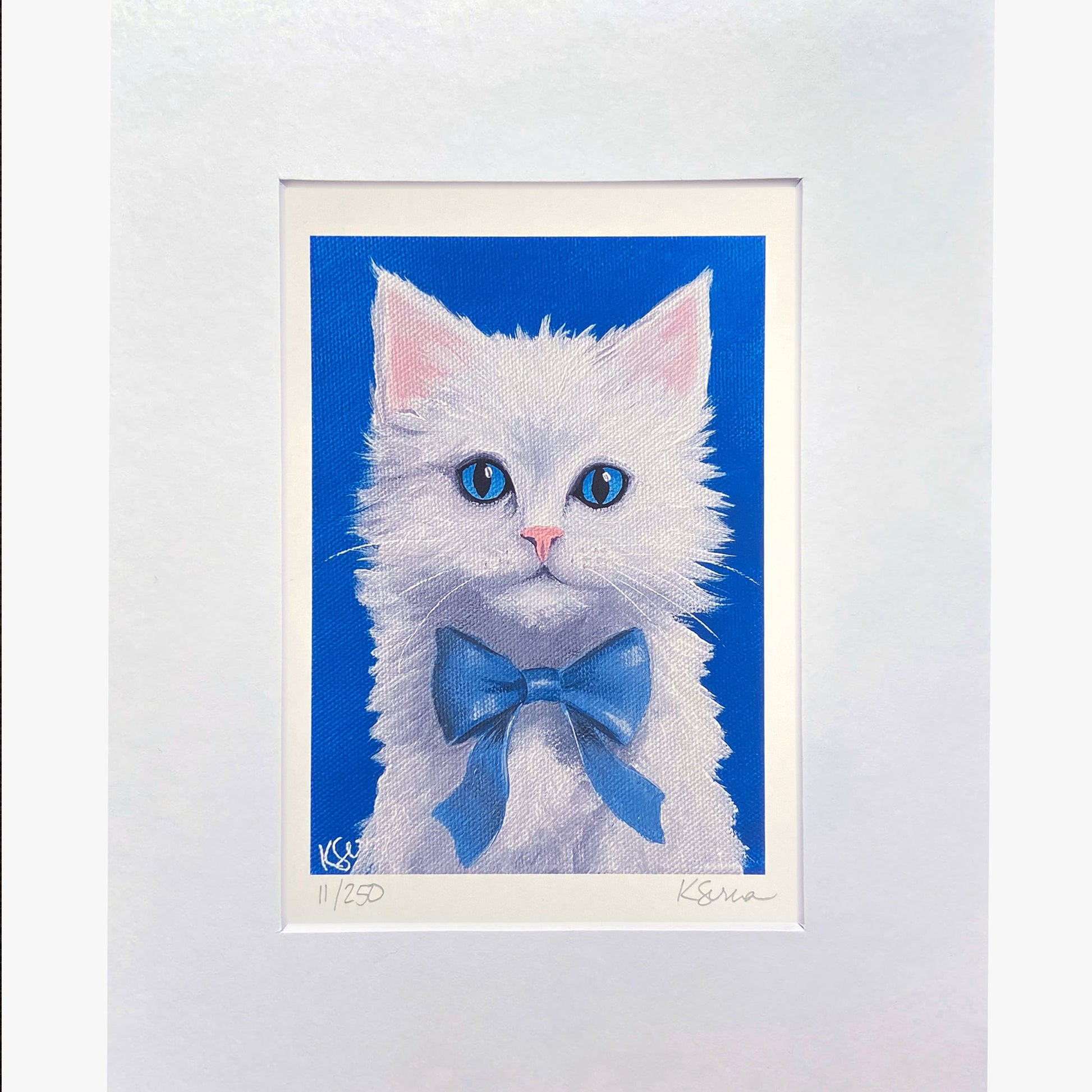 Framed artwork of a white cat with blue eyes and a blue bow tie on a blue background.