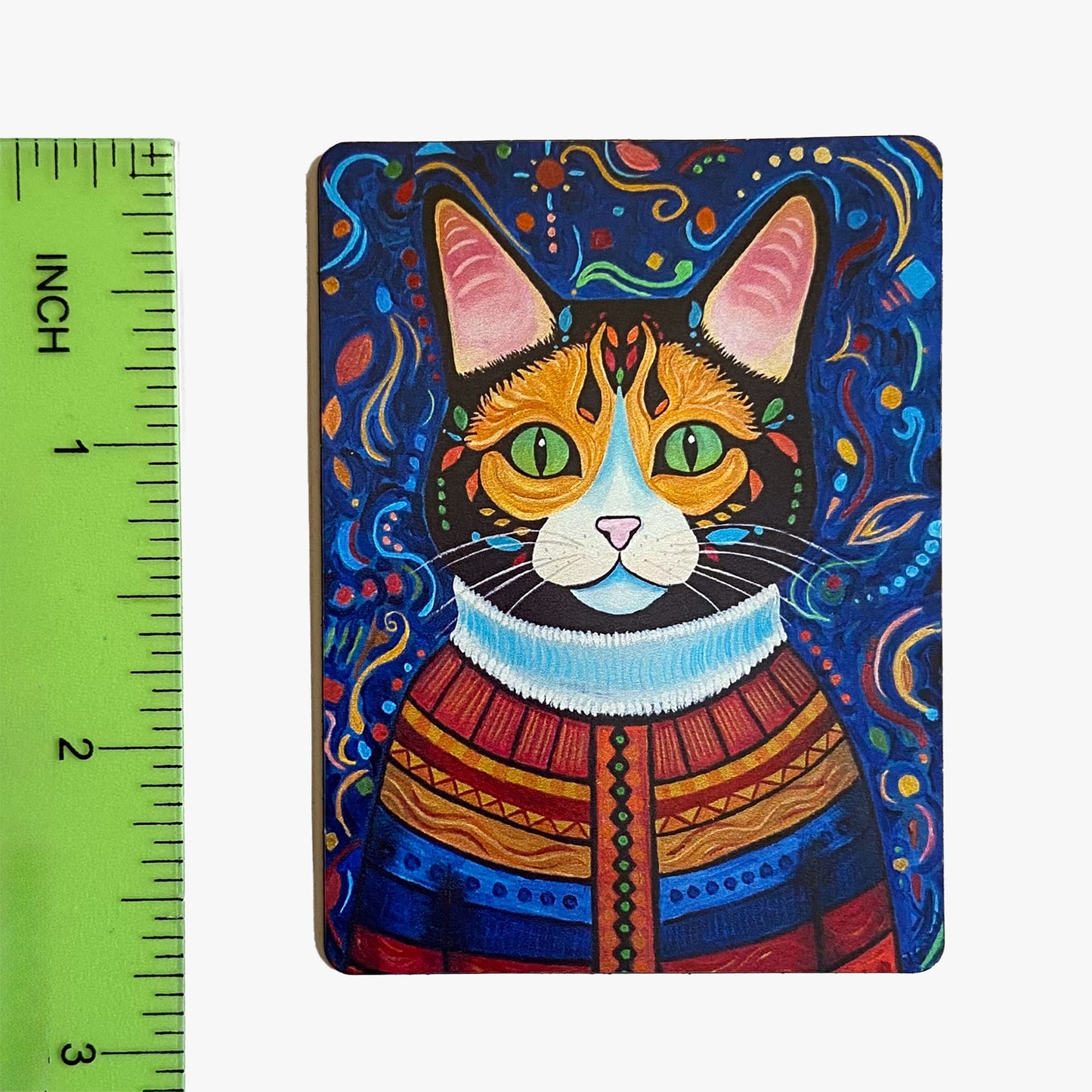 Colorful cat illustration on a magnet with a ruler for scale.