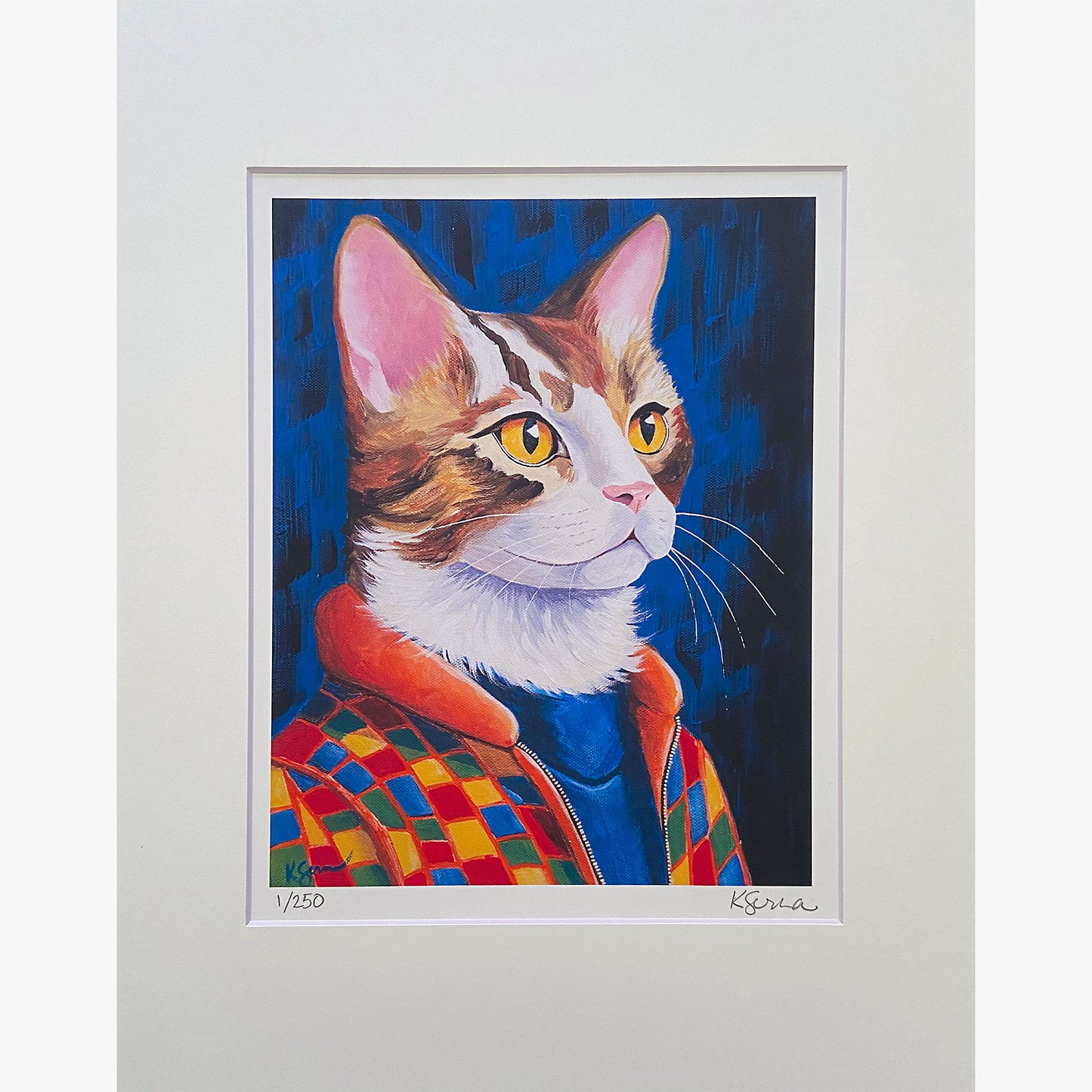 A close-up of a limited edition print featuring Jasper the Cat, a striking painting of a confident tabby cat with golden eyes. Jasper wears a bold checkered jacket with an orange collar over a blue turtleneck. The background is a deep, textured blue. The print is matted with a white border, and the artist's signature and edition number (1/250) are visible at the bottom.