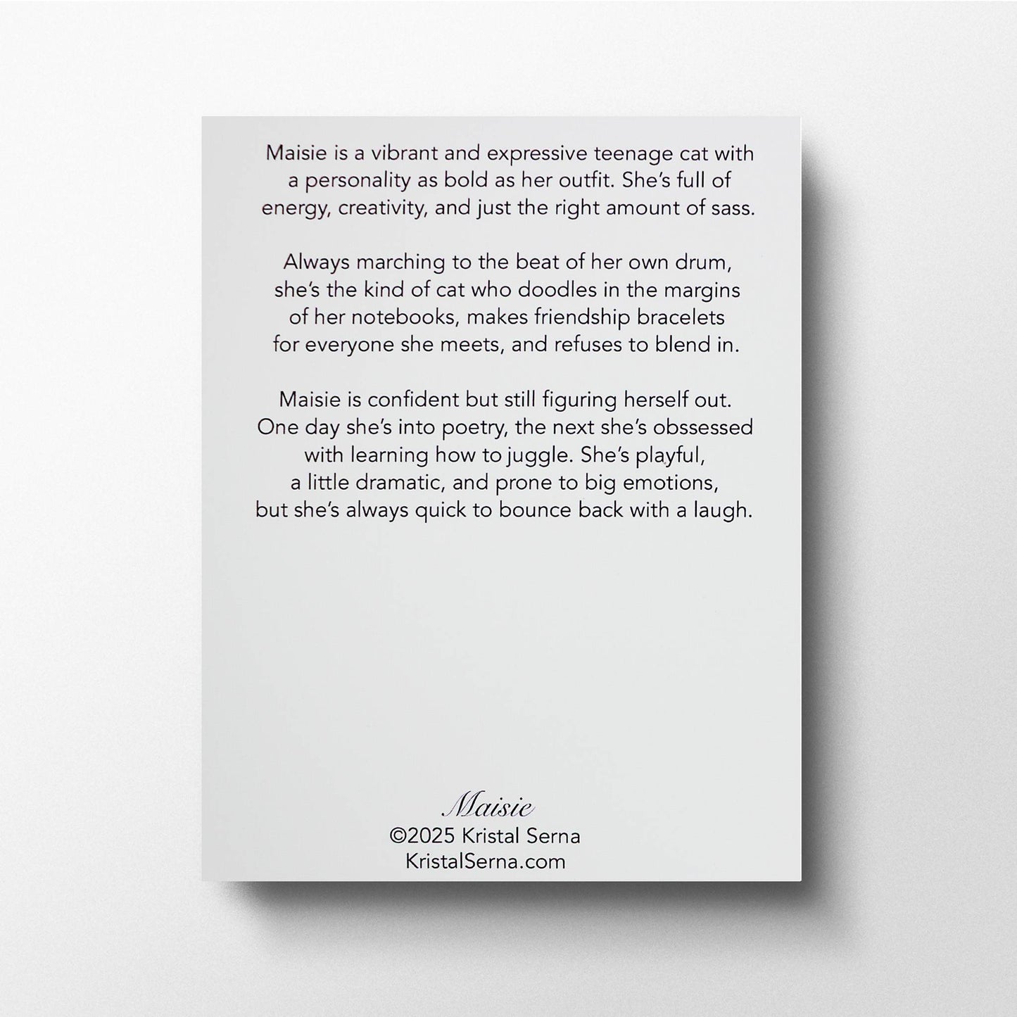 A printed card featuring a description of Maisie the Cat’s personality. The text highlights her as an expressive, creative, and slightly dramatic teenage cat who loves making friendship bracelets, exploring new interests, and embracing her individuality. The card includes the artist’s name, Kristal Serna, and her website at the bottom.