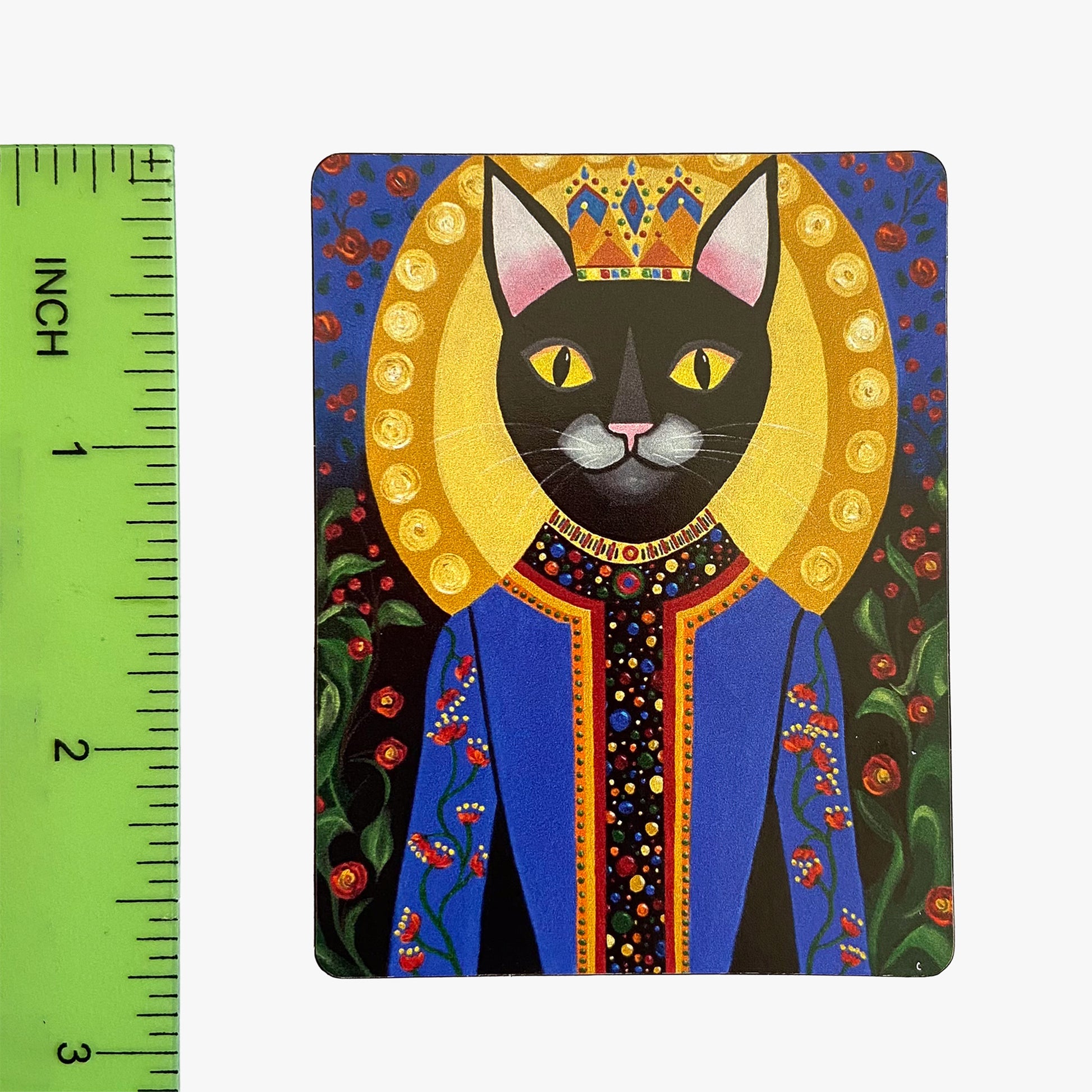 Magnet with a black cat in royal attire next to a ruler for scale