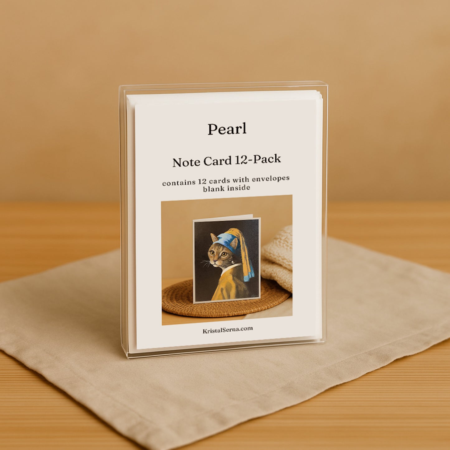 Note card set with cat illustration and 'Pearl' branding on a beige surface.