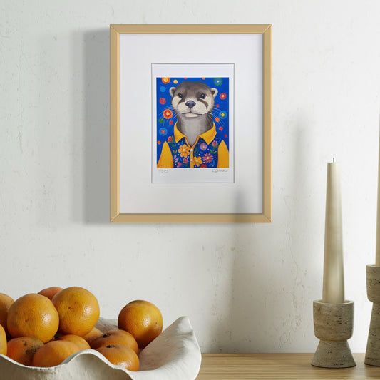 Framed artwork of a bear in a floral shirt on a wall above a bowl of oranges.