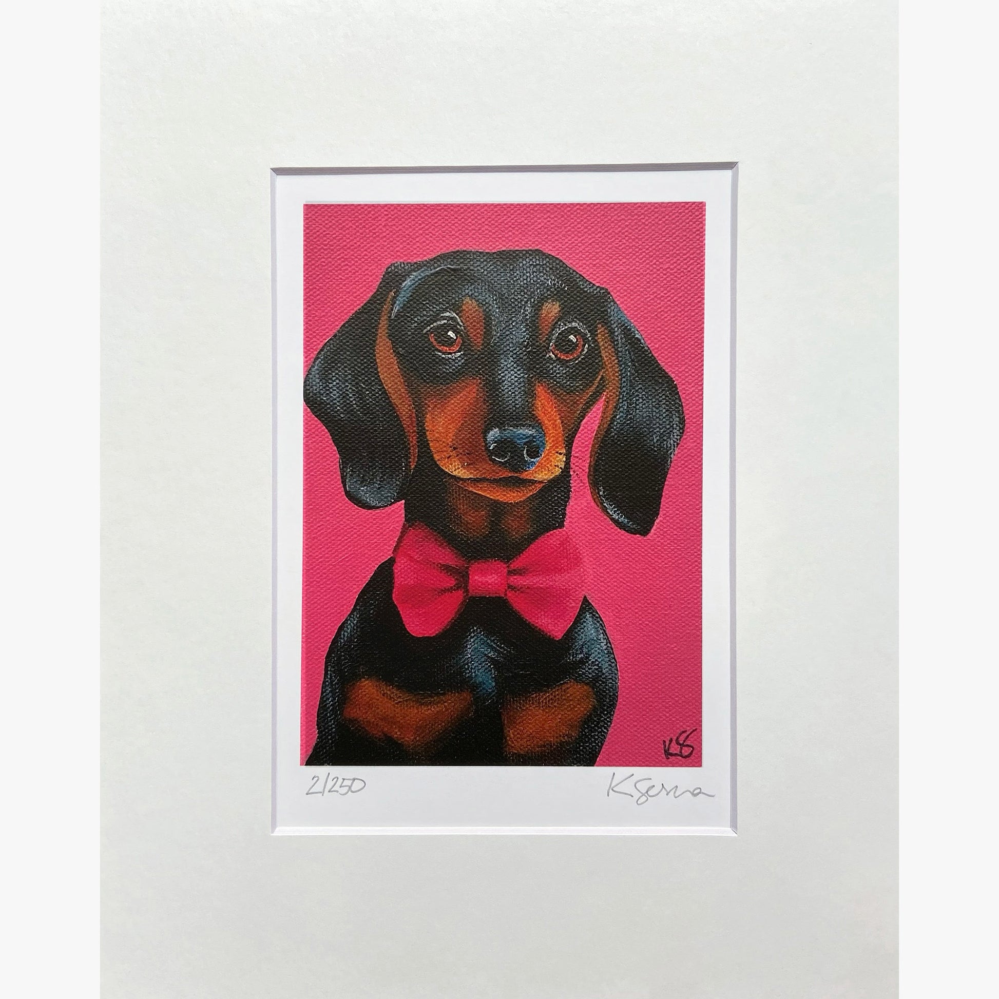 Framed artwork of a dachshund with a pink bow tie on a pink background
