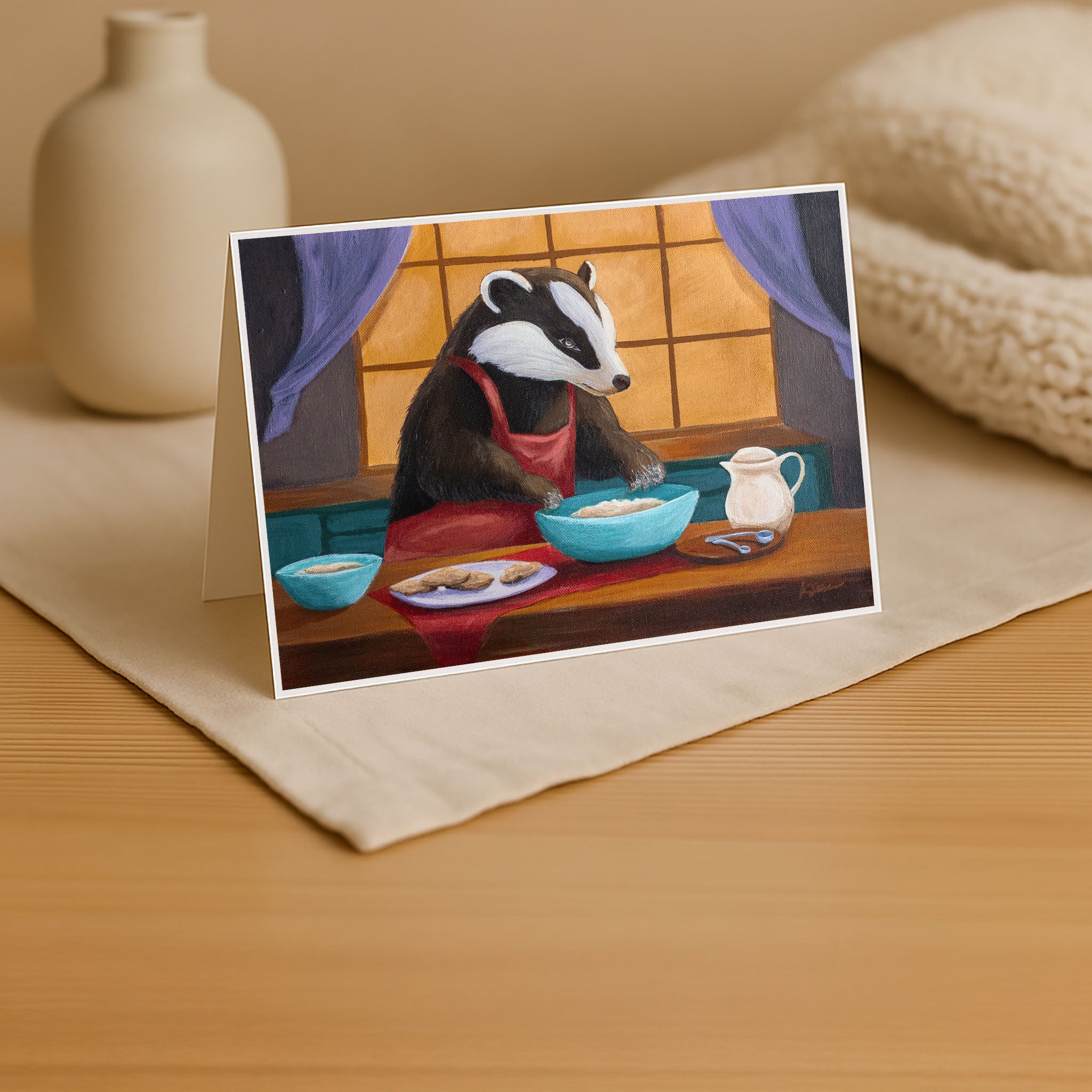 Greeting card with a badger character at a table on a wooden surface