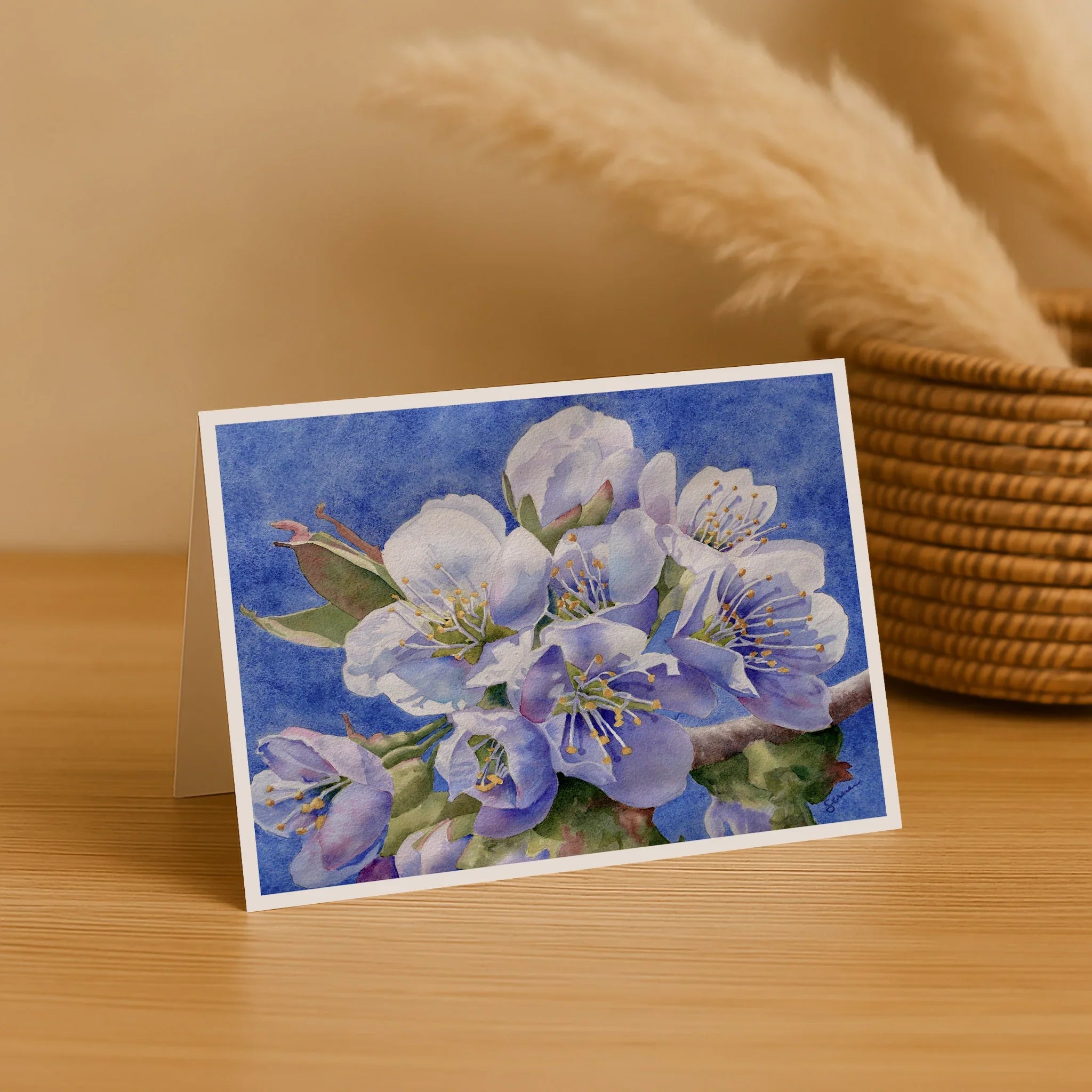 Greeting card with floral design on a wooden surface with a blurred background