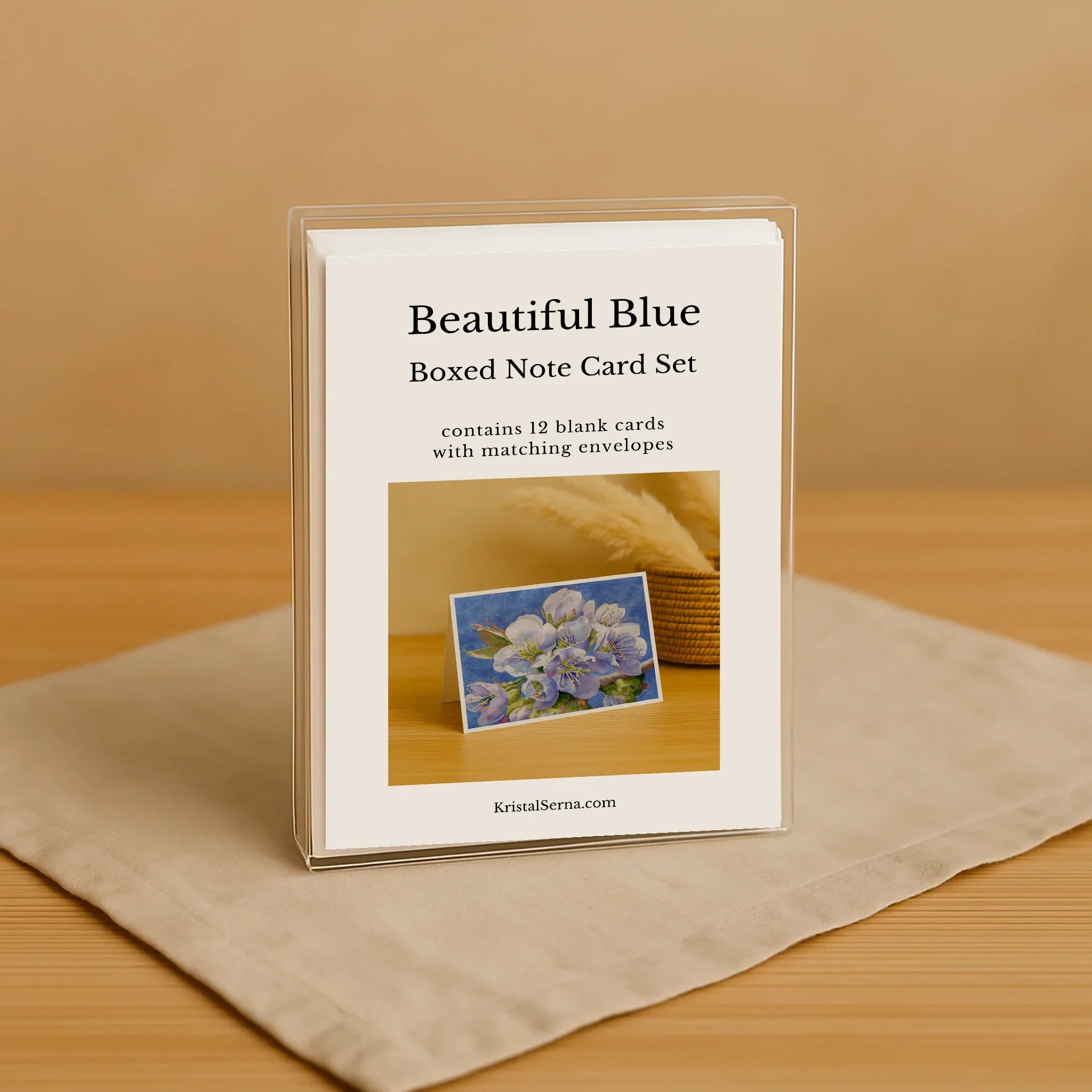 Boxed note card set with floral design on a beige surface