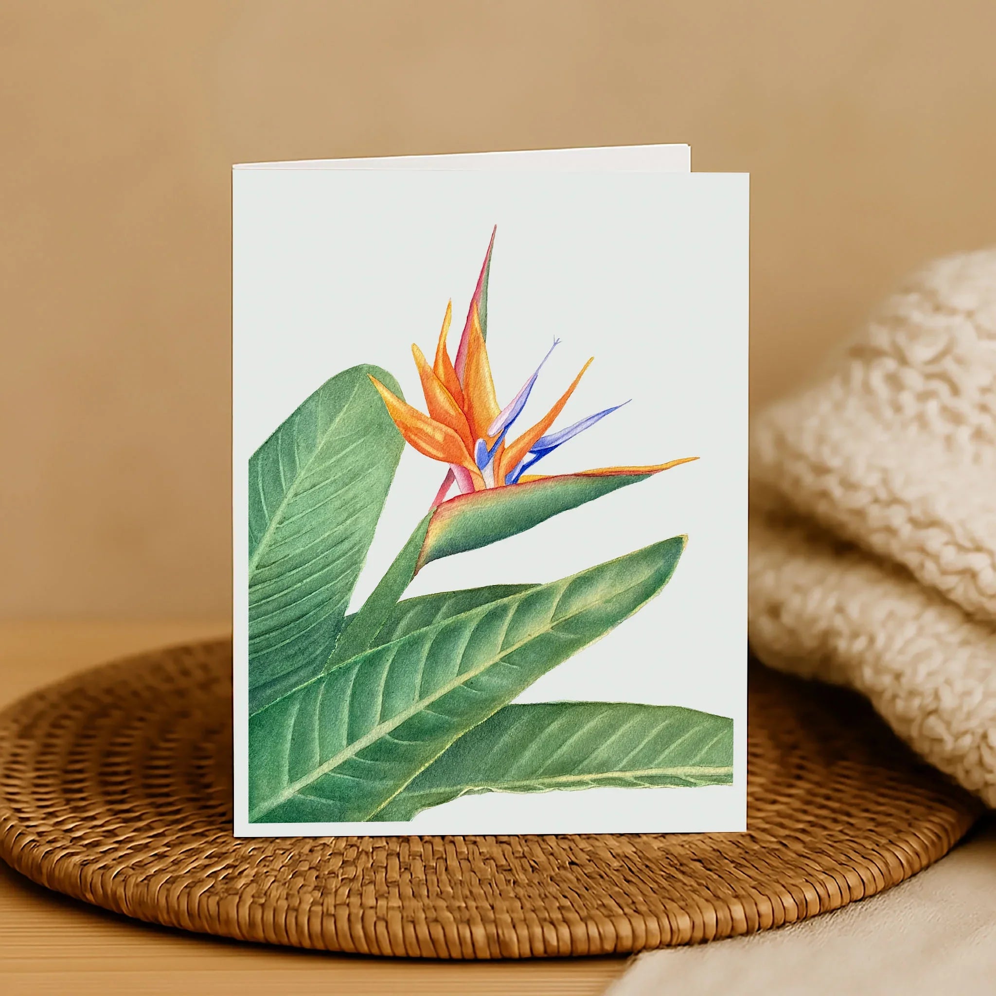 Greeting card with a tropical flower design on a woven surface.