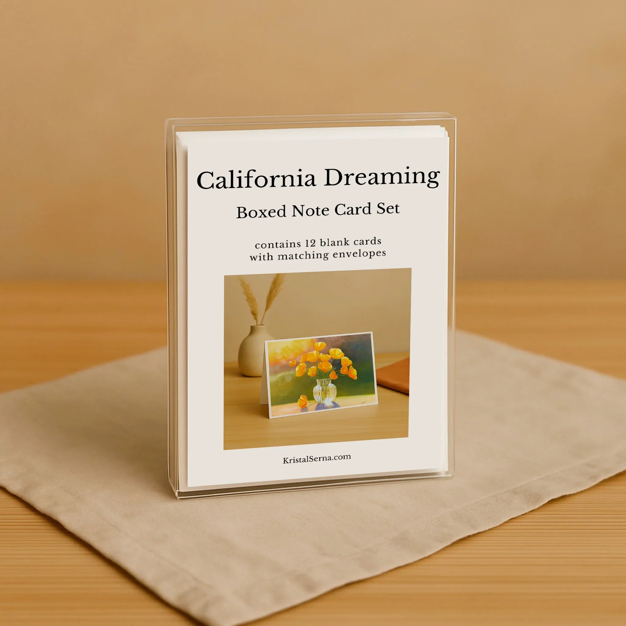 Boxed note card set titled 'California Dreaming' on a beige surface with a wooden background