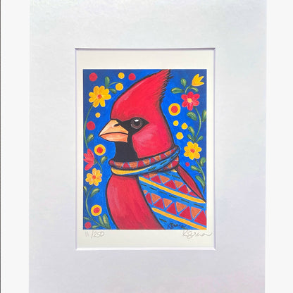Framed artwork of a red cardinal bird with floral patterns on a blue background.