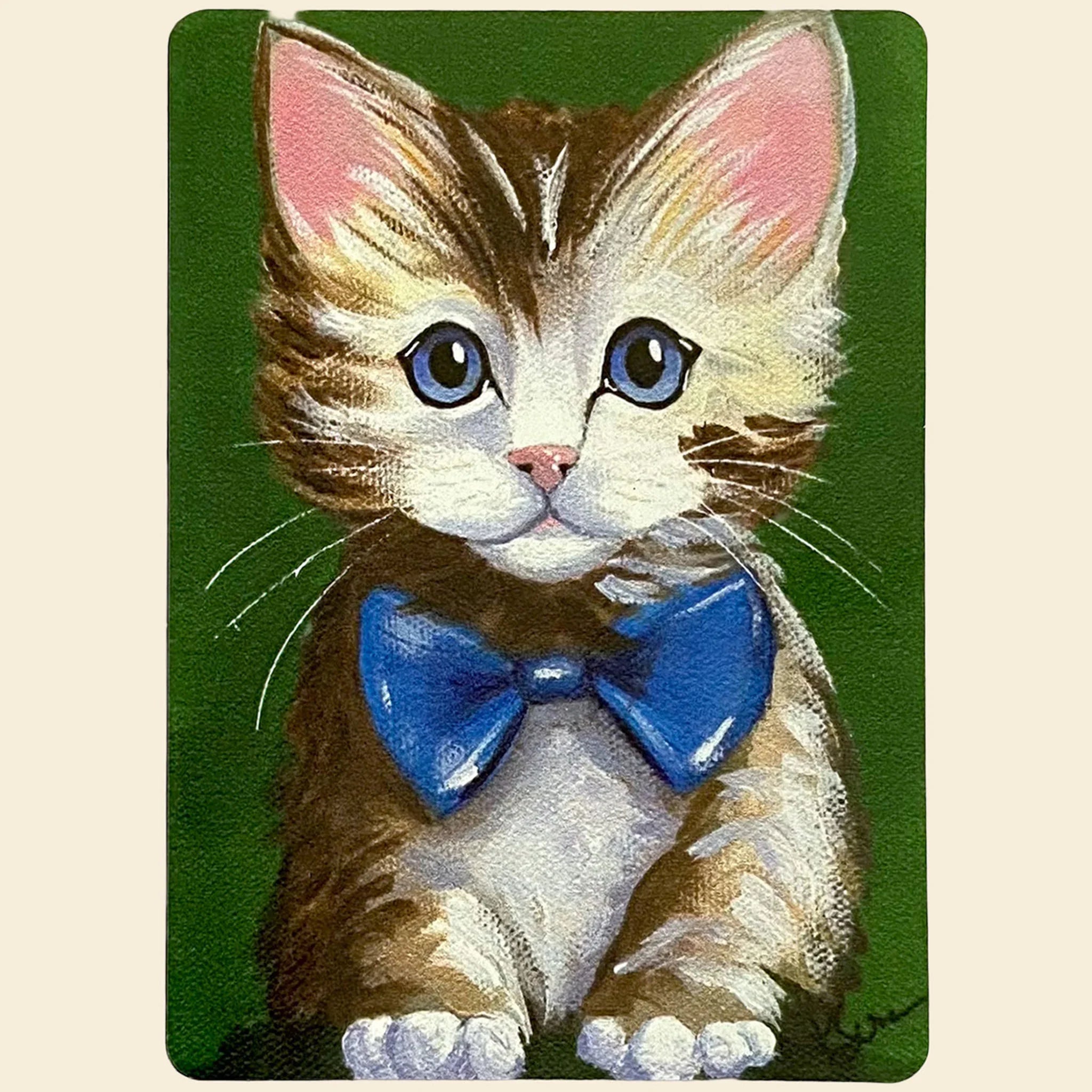Magnet of a kitten with a blue bow tie on a green background