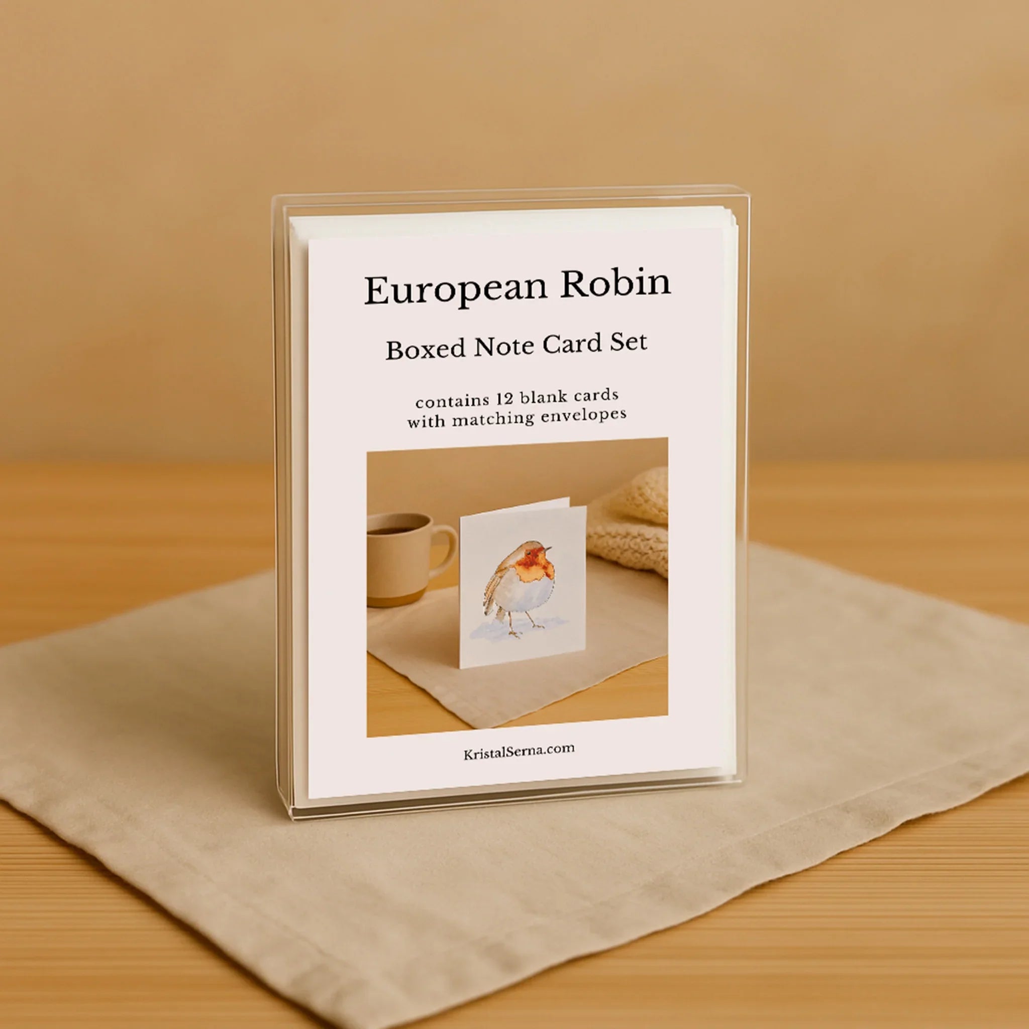 Boxed note card set with a bird illustration on a beige surface