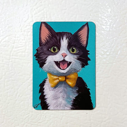 Fridge magnet with a cartoon cat wearing a yellow bow tie on a white background