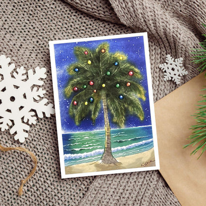 A watercolor and ink painting of a palm tree decorated with Christmas lights beside the ocean at night, with stars shining above.