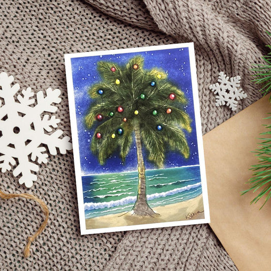 A watercolor and ink painting of a palm tree decorated with Christmas lights beside the ocean at night, with stars shining above.