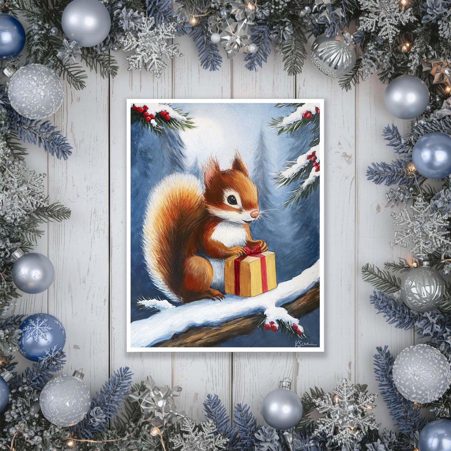 artwork of a squirrel with a gift surrounded by Christmas decorations on a wooden surface.