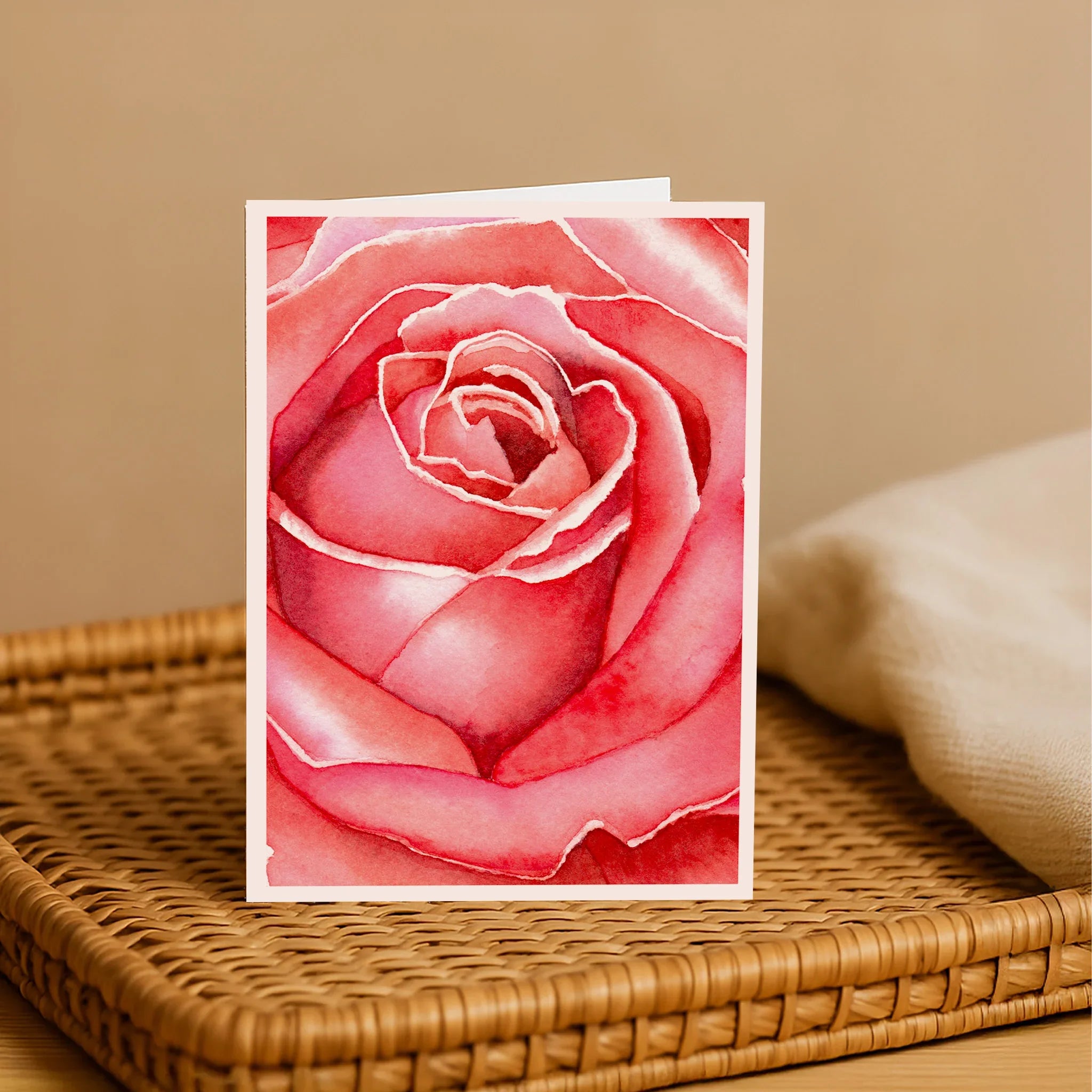 Card with a pink rose design on a woven surface with a beige background