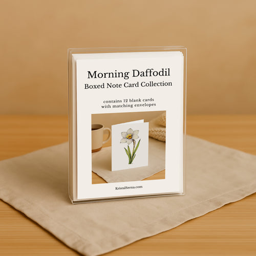 Boxed note card collection with a daffodil design on a beige surface.