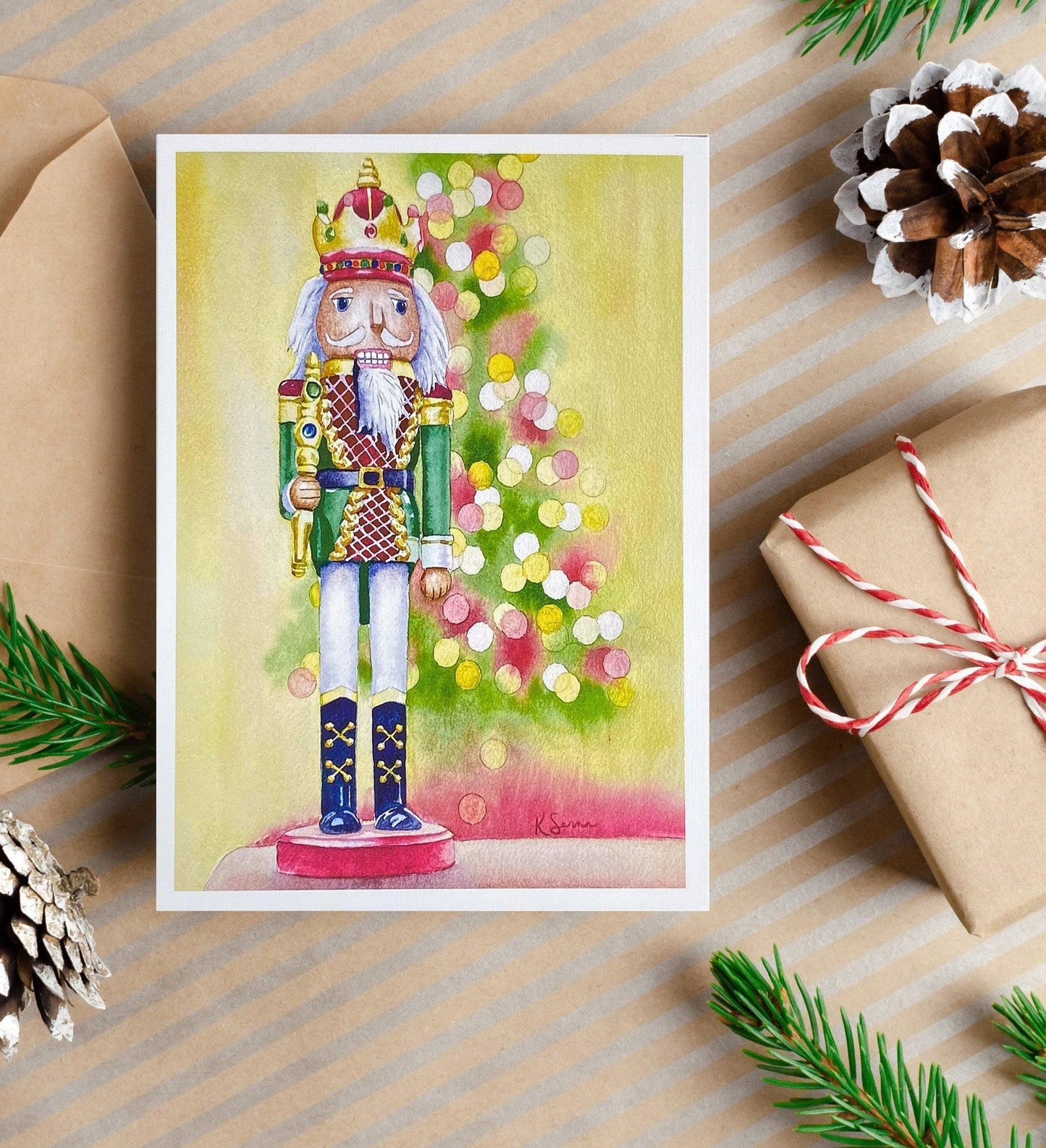 A watercolor painting of a traditional nutcracker soldier wearing a crown and standing in front of a softly glowing Christmas tree with colorful lights.