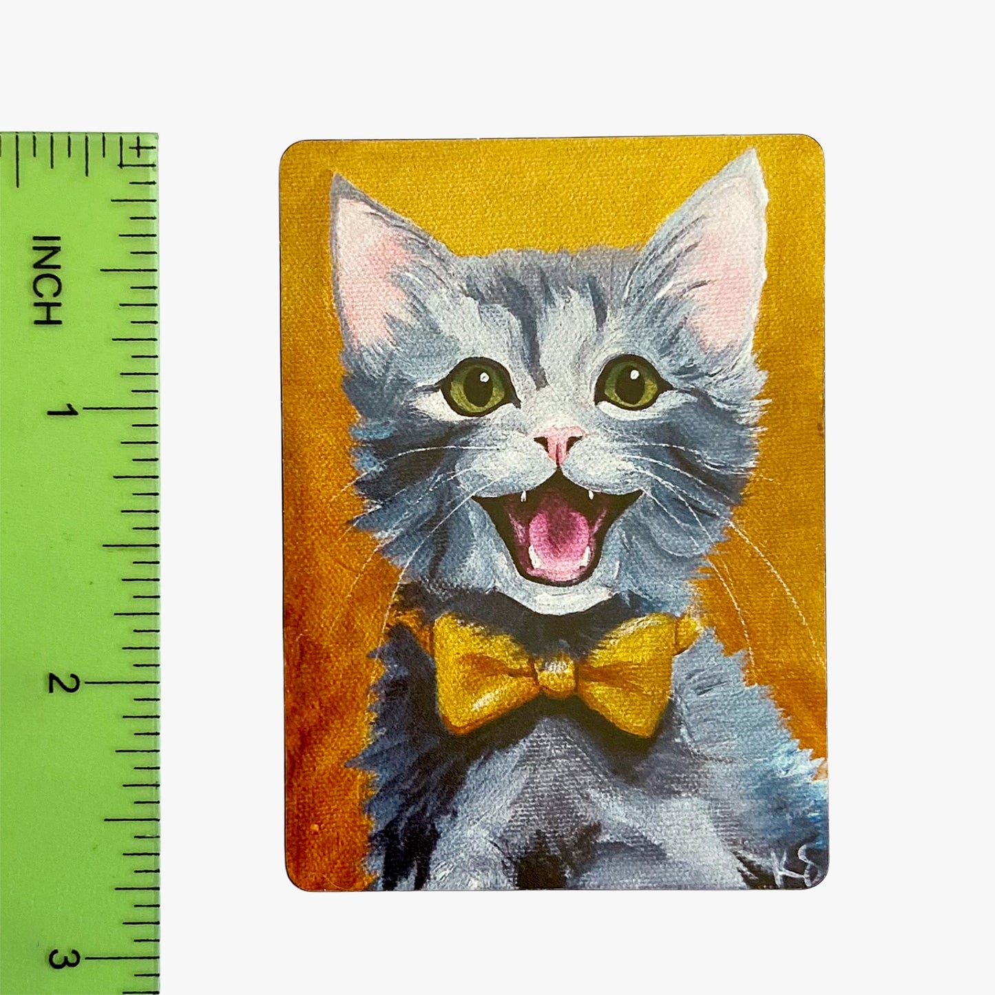 Painting of a cat with a yellow bow tie next to a ruler on an orange background
