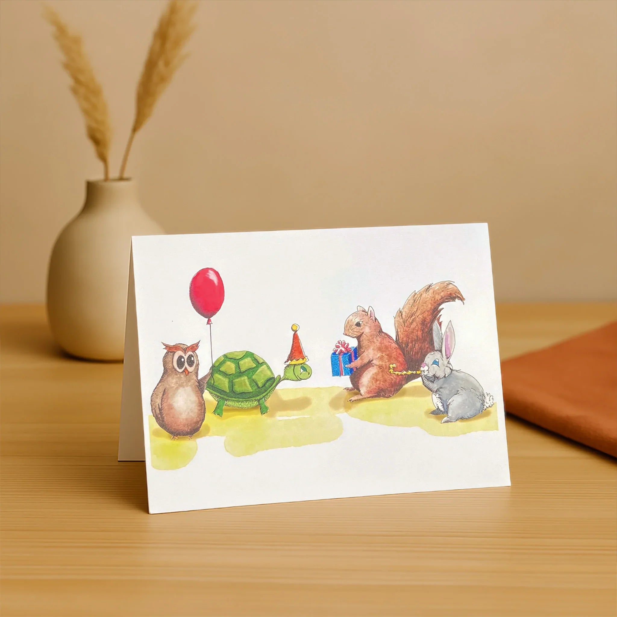Greeting card with animal illustrations on a wooden surface