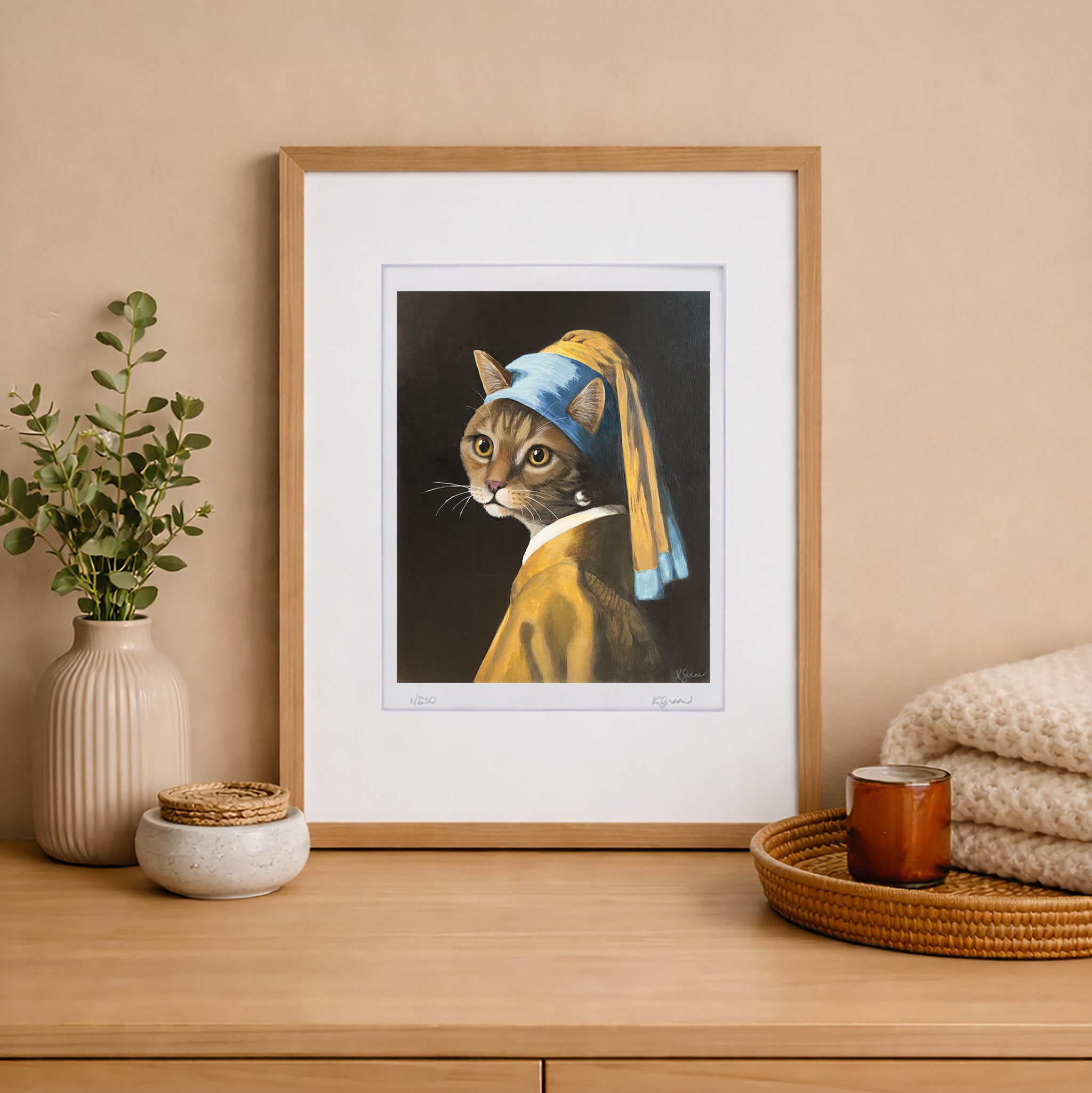 Framed artwork of a cat wearing a blue earring on a wooden shelf with decorative items.