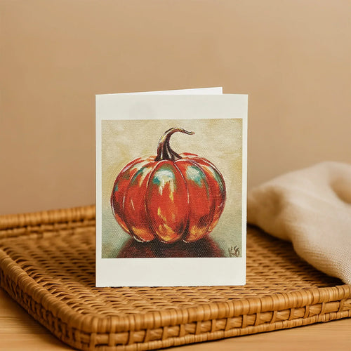 Greeting card with a pumpkin design on a woven surface
