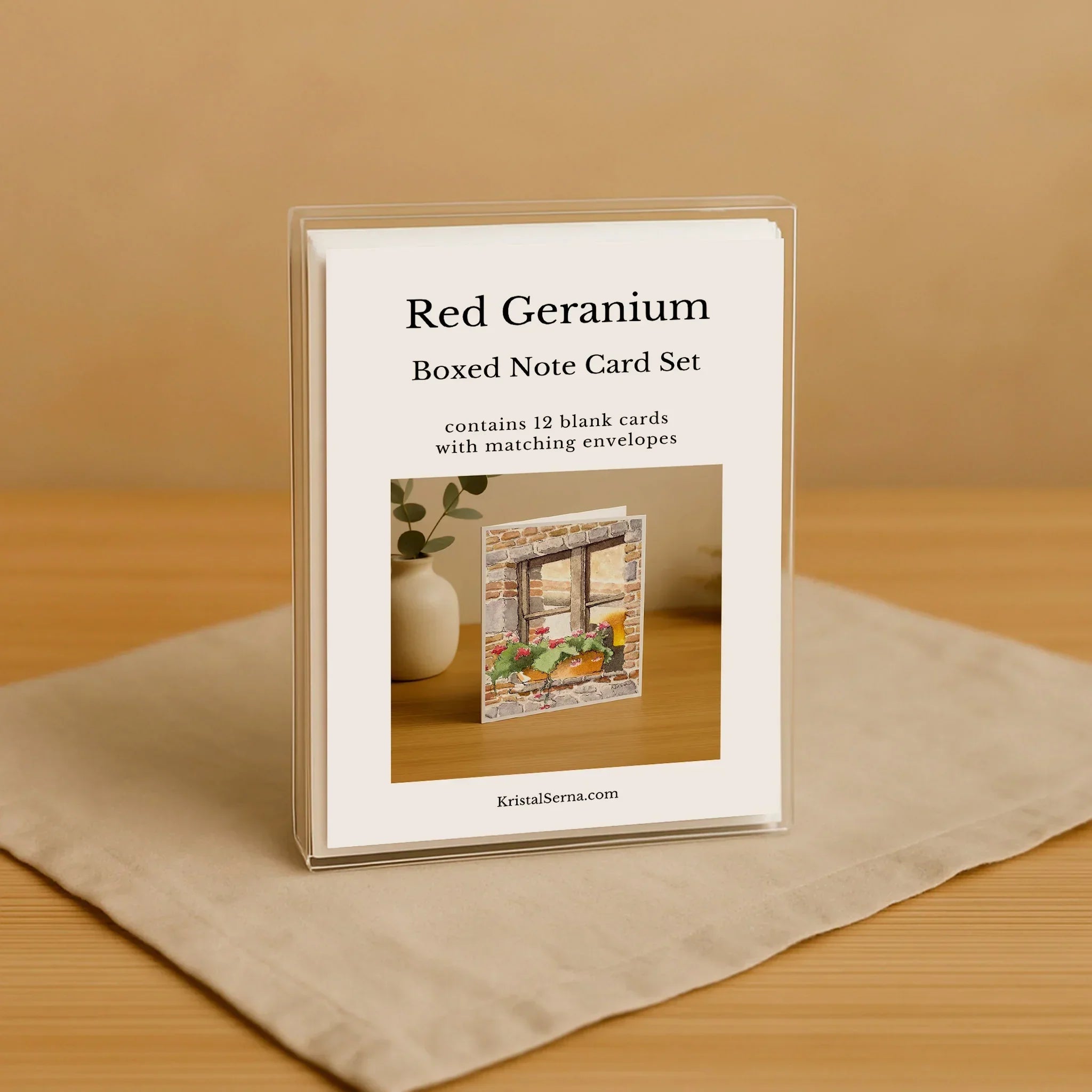 Red Geranium boxed note card set on a beige surface with a wooden background