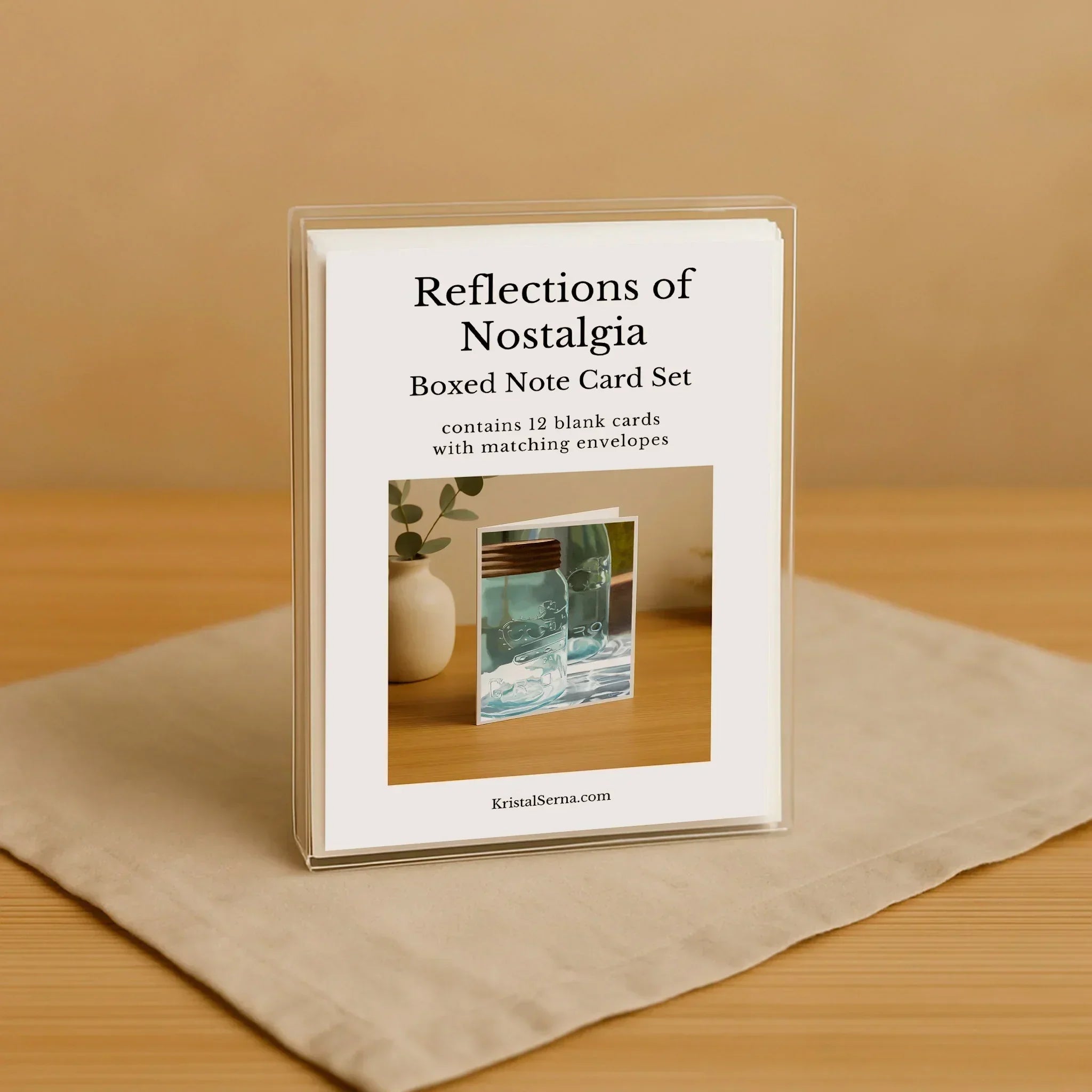 Boxed note card set titled 'Reflections of Nostalgia' on a wooden surface with a beige background.