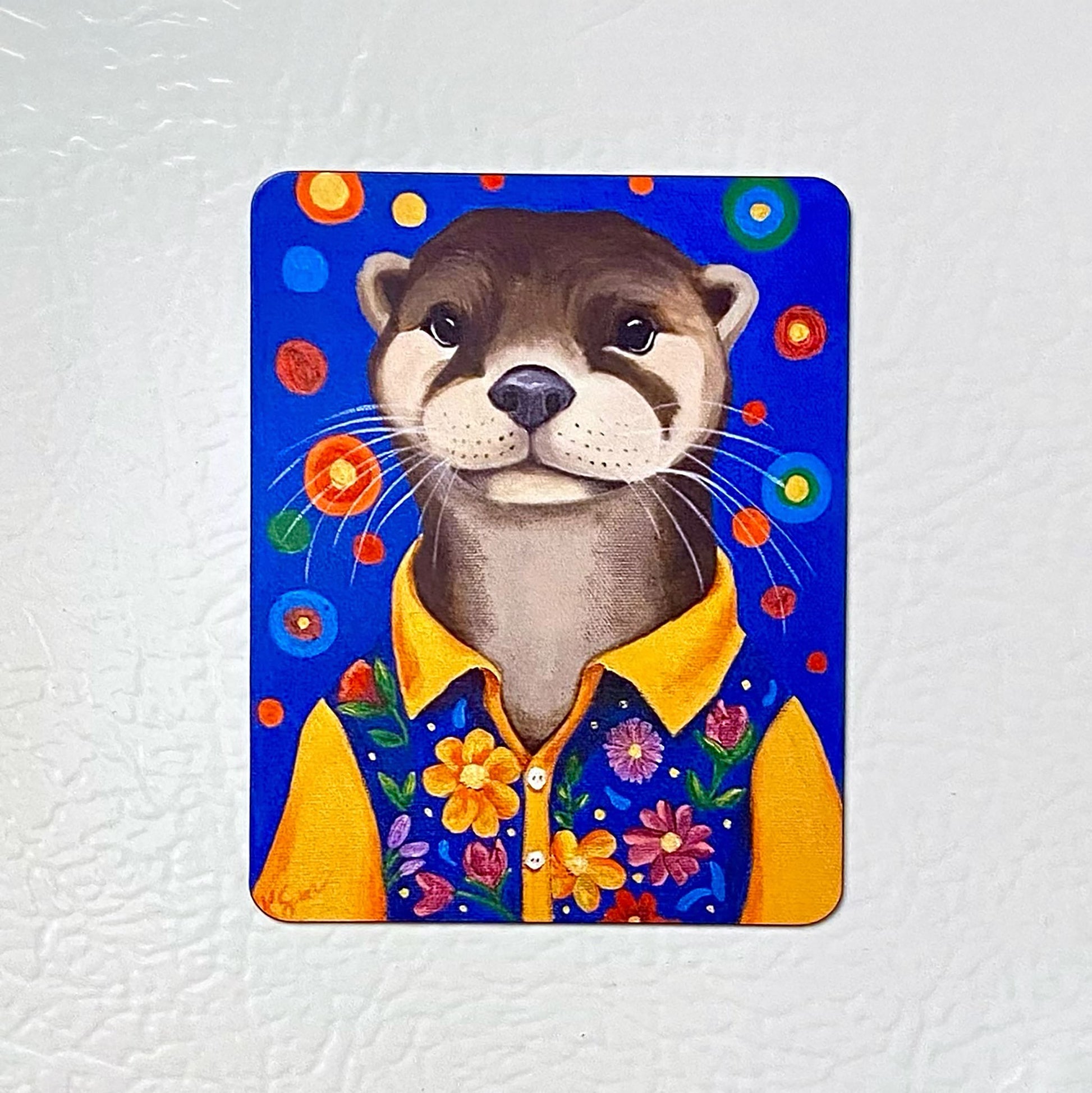 Magnet with a cartoon otter wearing a yellow shirt on a white background