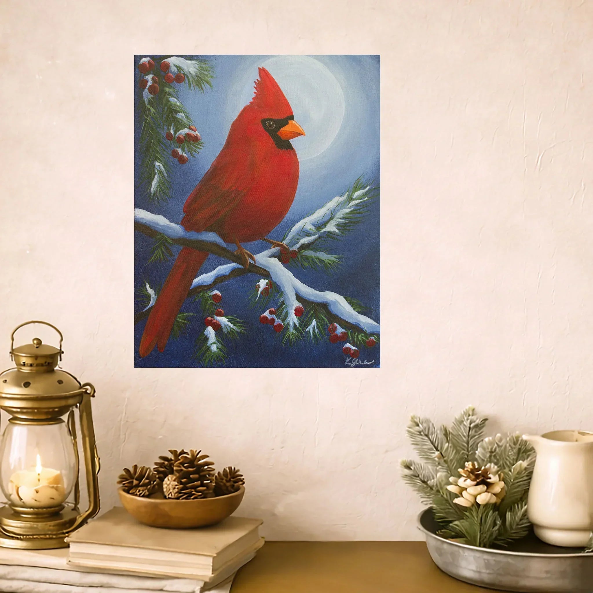 Painting of a red cardinal on a branch with berries, displayed on a wall above a decorative setup.