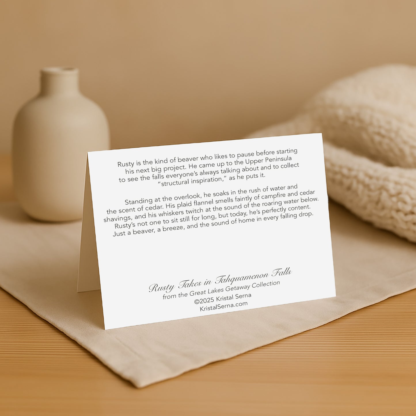 White card with text on a beige surface with a vase and fabric