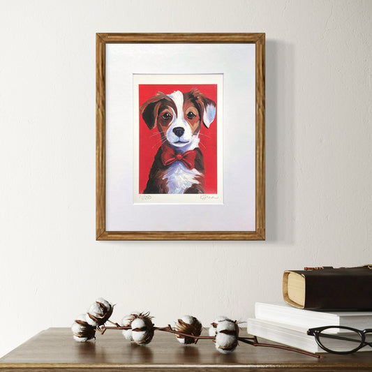 Framed artwork of a dog with a red background on a wall above a wooden surface.
