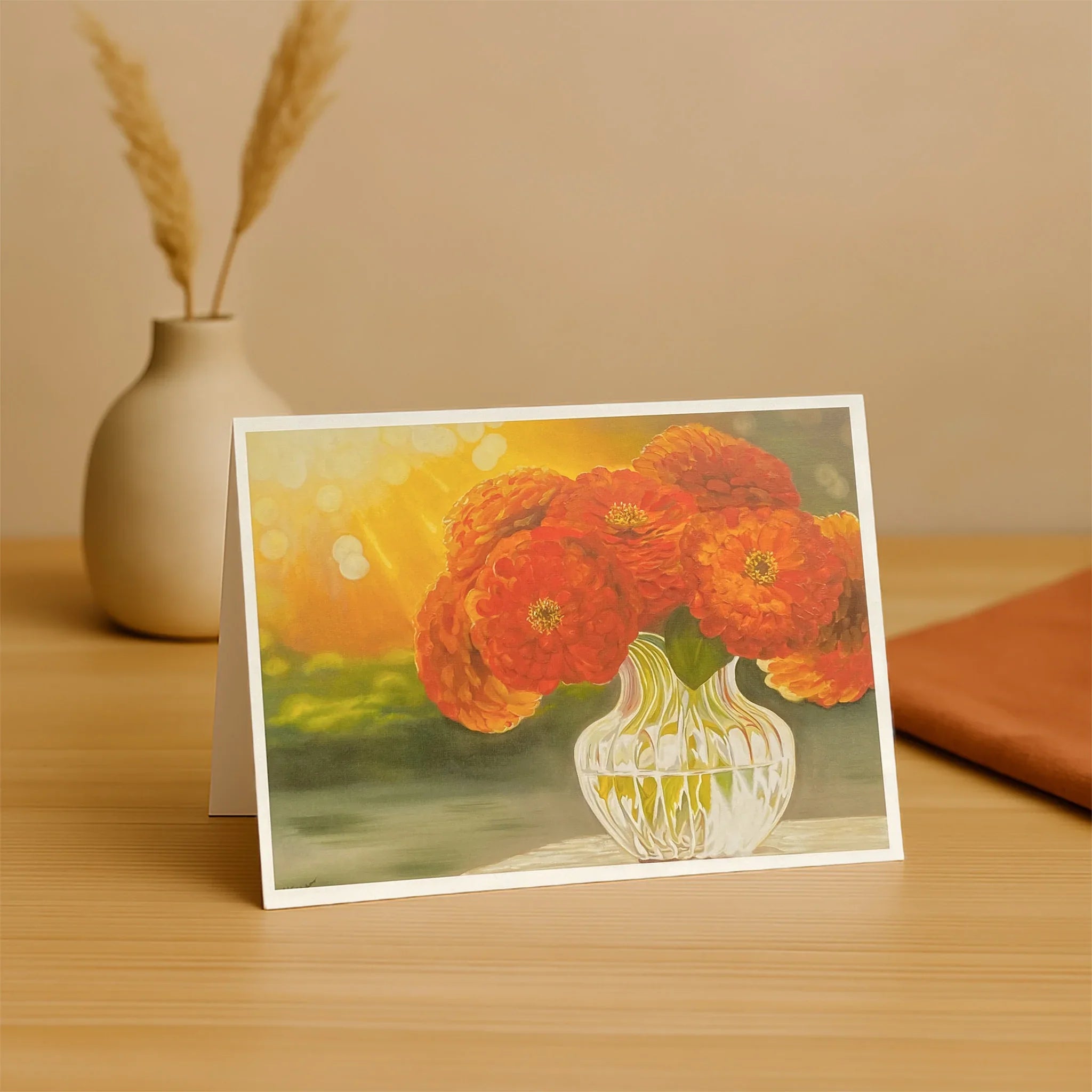 Greeting card with orange flowers in a white vase on a wooden surface.