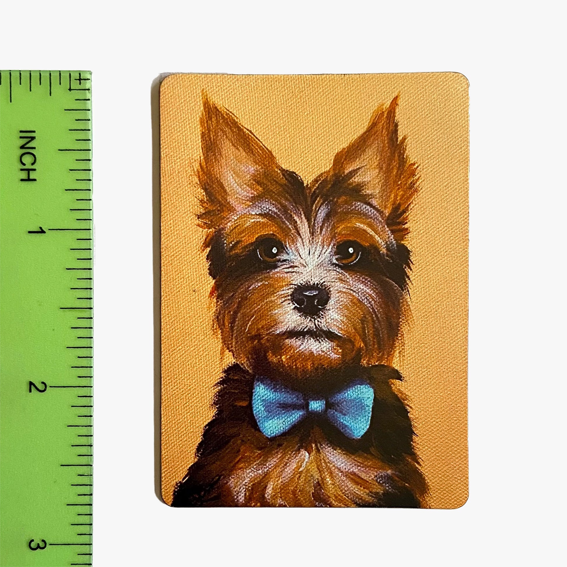 Painting of a dog with a bow tie next to a ruler on a white background