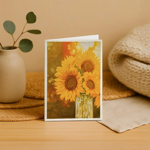 Greeting card with sunflower design on a wooden surface with decorative items.