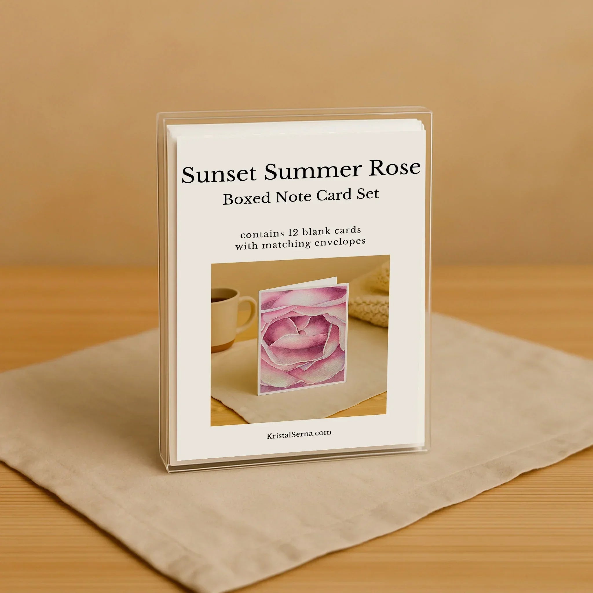 Boxed note card set titled 'Sunset Summer Rose' on a beige surface with a wooden background.