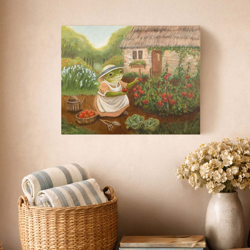 Framed artwork of a frog gardener on a wall above a basket with striped towels and a vase with flowers.