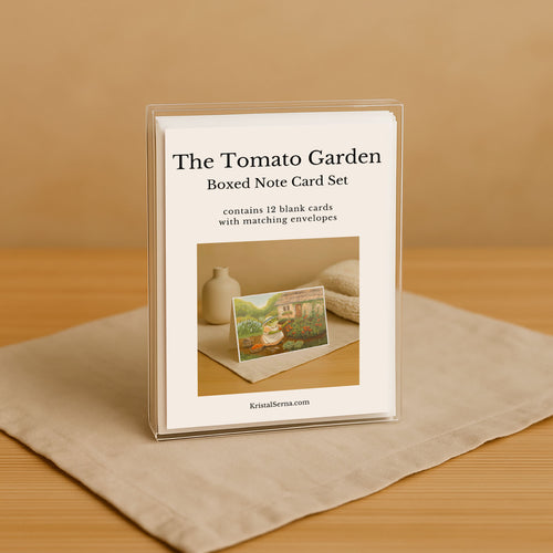 Boxed note card set titled 'The Tomato Garden' on a beige surface with a brown background