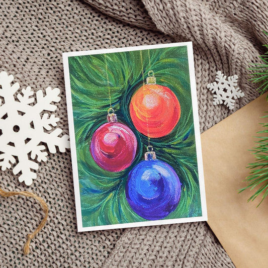 An acrylic painting of three Christmas ornaments—red, pink, and blue—hanging from green pine branches.