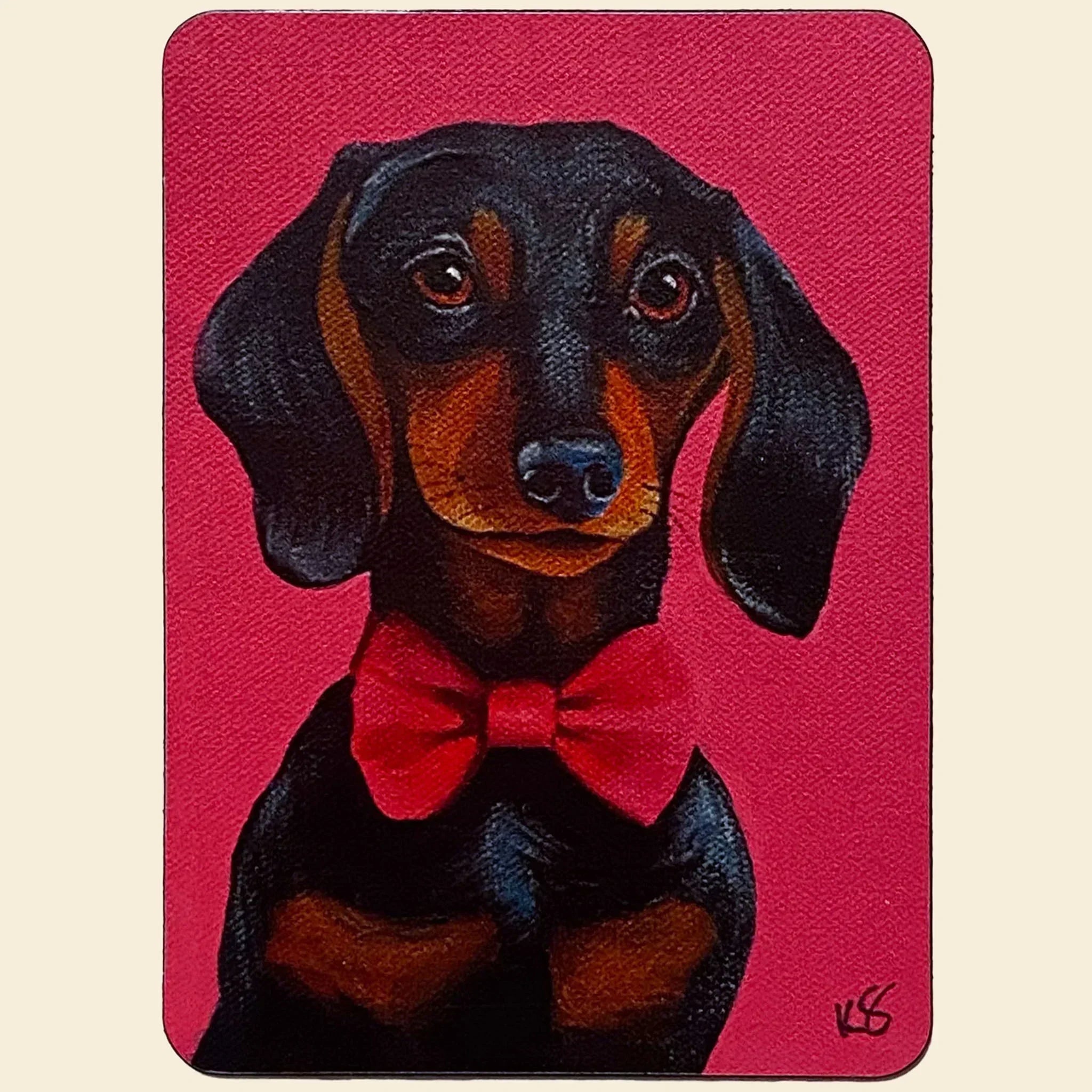 Magnet of a dachshund with a red bow tie on a pink background