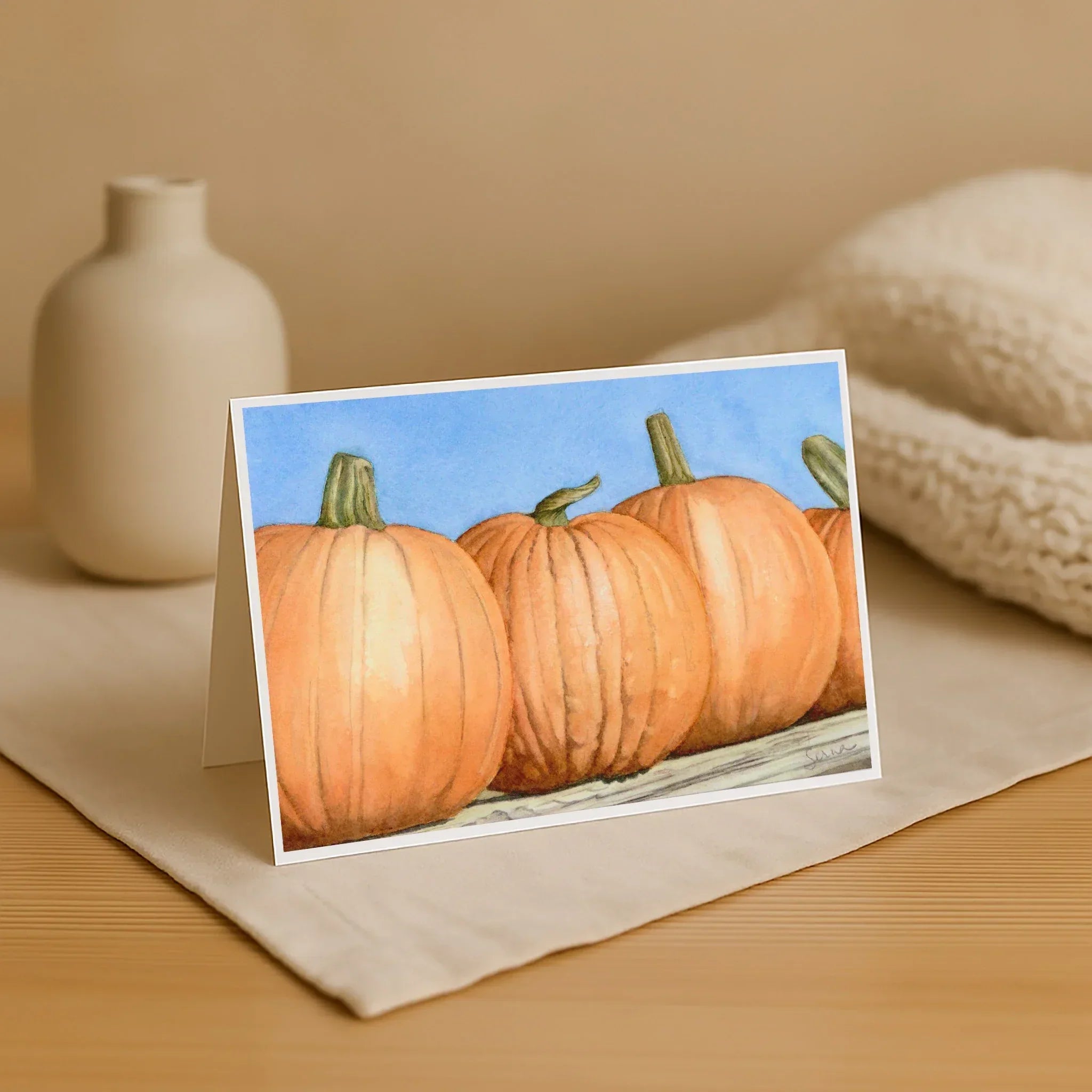 Greeting card with pumpkins on a beige surface