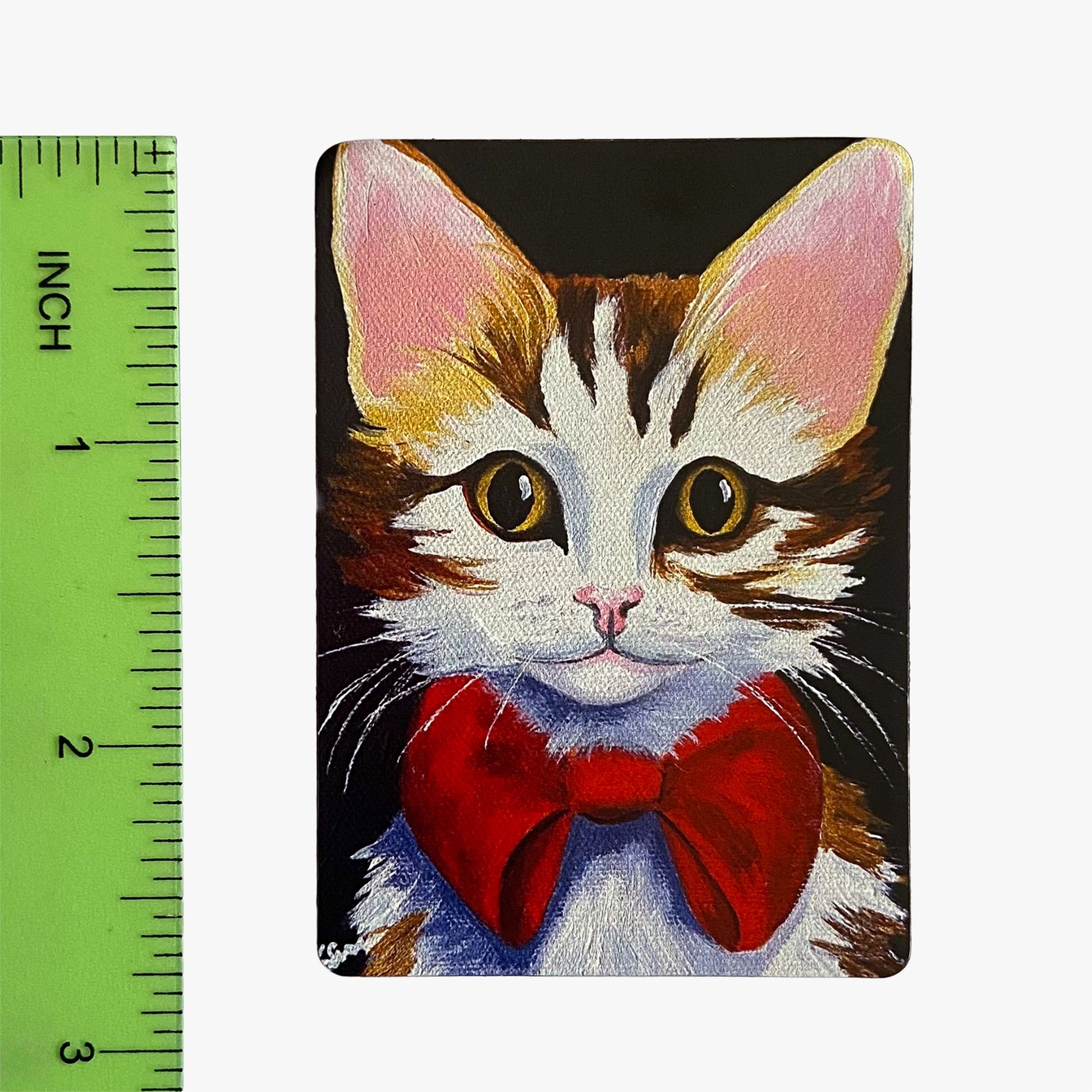 Painting of a cat with a red bow tie next to a ruler for scale.