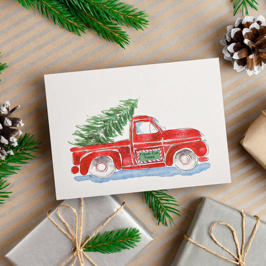 A watercolor and ink painting of a red vintage pickup truck with a green pine tree in the back and a sign on the door that reads “Fresh Cut Trees.”