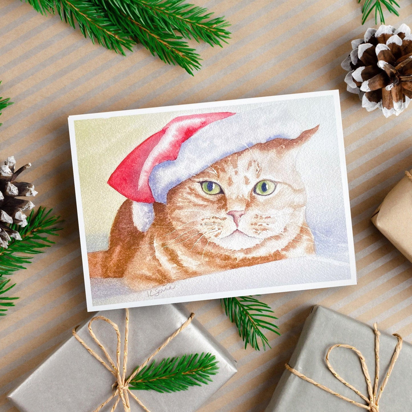 A watercolor painting of an orange tabby cat wearing a red and white Santa hat with a soft snowy background.