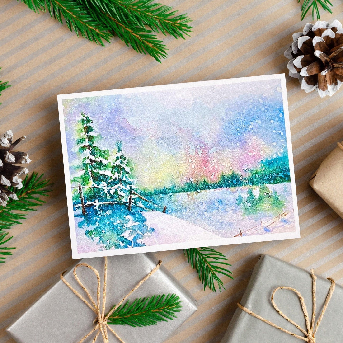 A watercolor painting of a snowy landscape with pine trees, a fence, and soft pastel colors in the sky reflecting on a frozen lake.